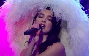 Dua Lipa Draws In Hilarious Comparisons for Feathered Hat Worn During 'SNL' Performance
