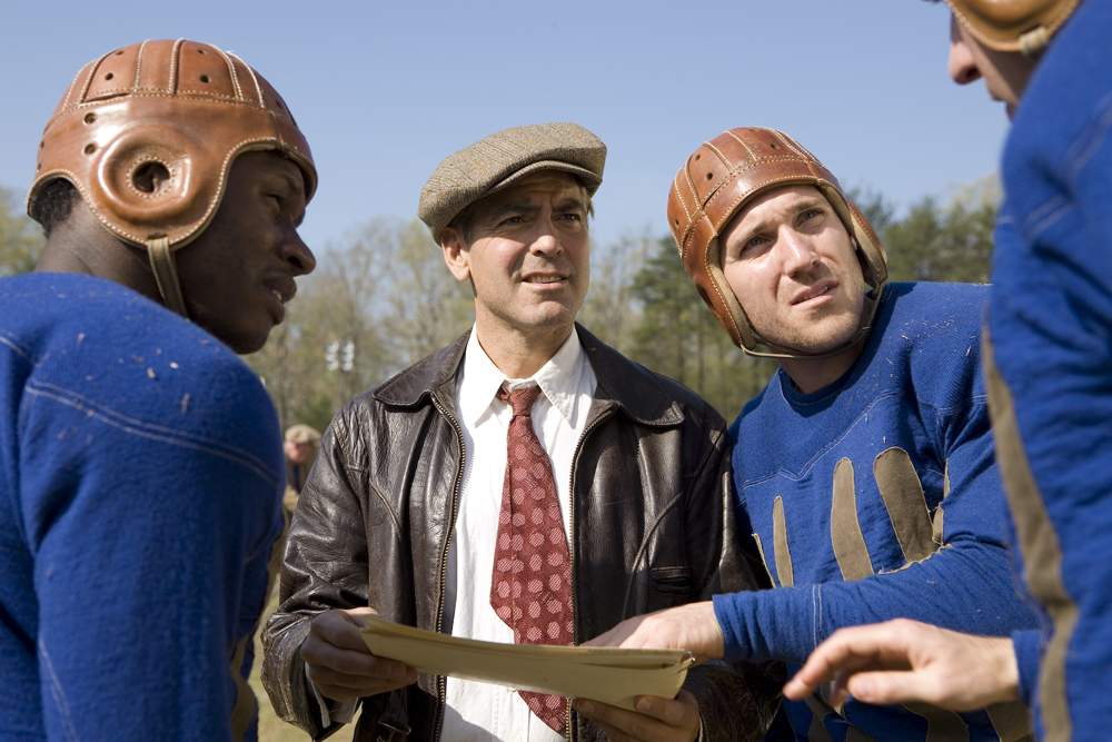 Bakes (MALCOLM GOODWIN), Bulldogs team captain Dodge Connolly (GEORGE CLOONEY) and Zoom (NICK PAONESSA) discuss strategy in Leatherheads (2008).