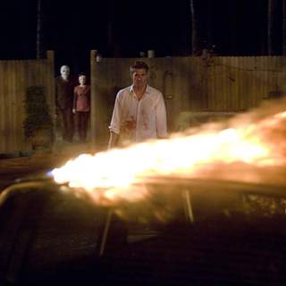The Man in the Mask (KIP WEEKS) and Pin-Up Girl (LAURA MARGOLIS) stalk James Hoyt (SCOTT SPEEDMAN) in Rogue Pictures' The Strangers (2008).