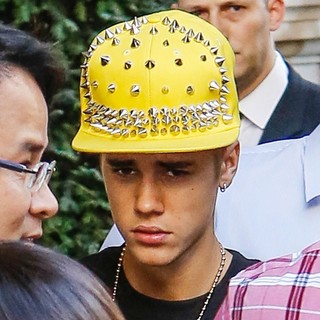 Justin Bieber Departs His Hotel Wearing A Yellow Studded Baseball Hat