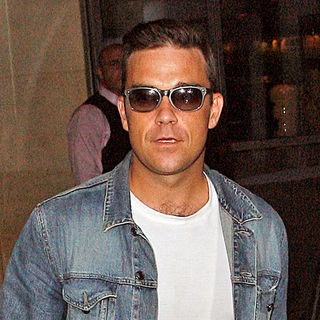 Robbie Williams in Robbie Williams Wearing A Denim Jacket and Jeans Leaves His Hotel