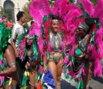It features steel pan bands and marchers covered in paint or oil