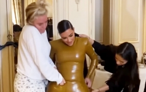 Watch: Kim Kardashian's Skintight Latex Outfit Gives Her a Real Struggle