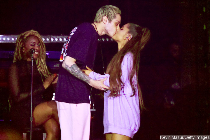 Ariana Grande and Pete Davidson lock lips onstage.