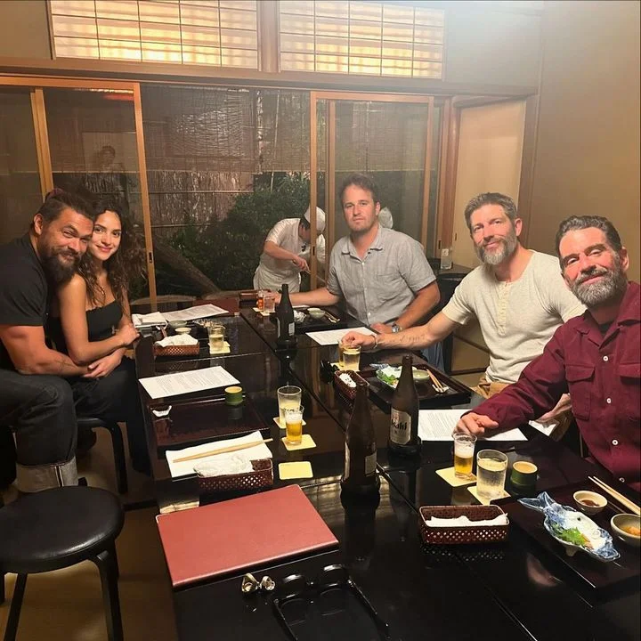 Adria Arjona sits on Jason Momoa's lap
