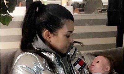 Kourtney Kardashian Cradles Baby Doll While Covering Her Belly in New Pic