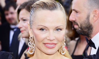 Pamela Anderson Flashes Cleavage in Plunging Summer Dress in Saint Tropez