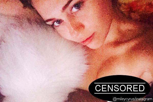 Miley Cyrus Shows Off Her Boob While Striking a Pose With Her Kitty