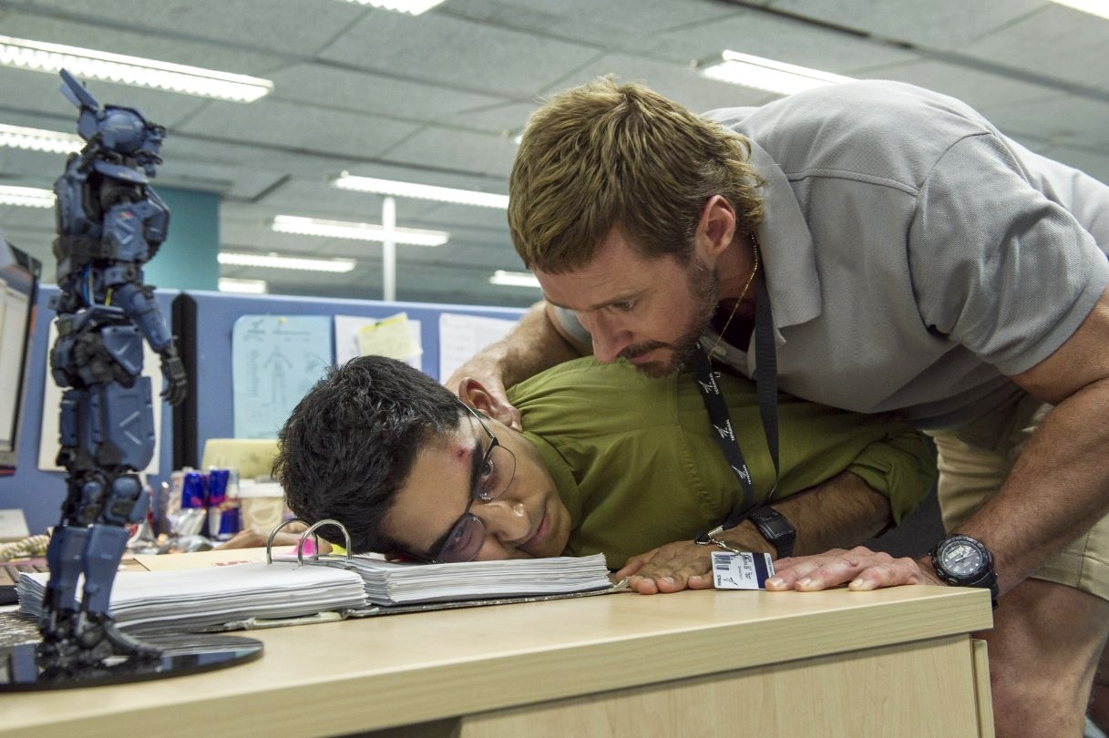 Dev Patel stars as Deon Wilson and Hugh Jackman stars as Vincent Moore in Columbia Pictures' Chappie (2015)