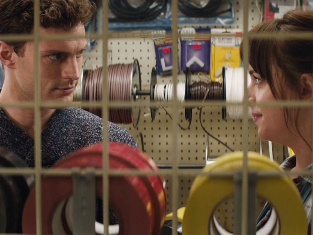 Jamie Dornan stars as Christian Grey and Dakota Johnson stars as Anastasia Steele in Focus Features' Fifty Shades of Grey (2015)