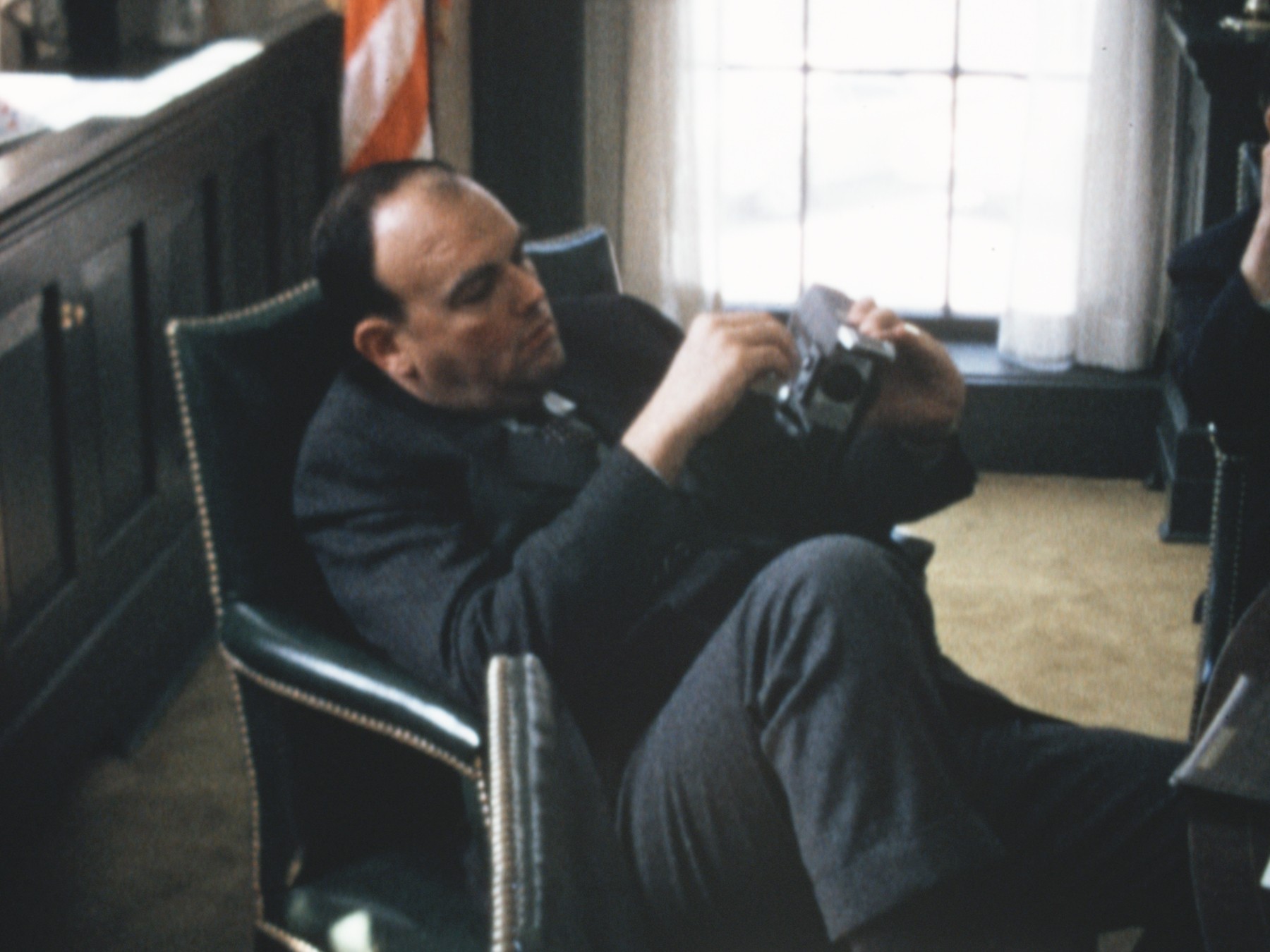 Chief Domestic Advisor John Ehrlichman fiddles with his Super 8 camera during a particularly boring staff meeting at the White House