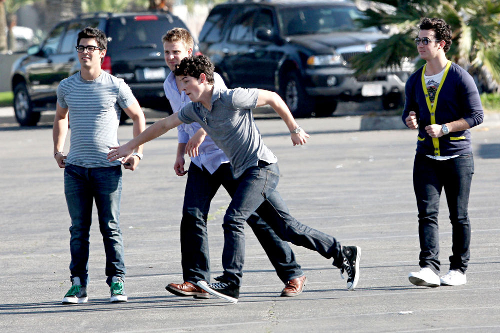 Jonas Brothers;<br>Jonas Brothers playing American football between scenes on the set 'Chasing Butterflies'